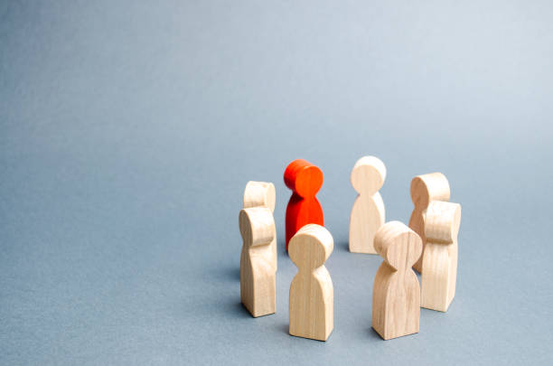 istock People stand in a circle on a gray background. Communication. Business team, teamwork, team spirit. Wooden figures of people. A circle of people. discussion, cooperation, cooperation. Selective focus 1142897769