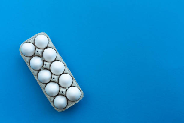 istock White chicken eggs in an open cardboard box on a blue background. A dozen eggs in eco-friendly packaging .. Healthy organic food and diet concept. Easter theme 1142899029