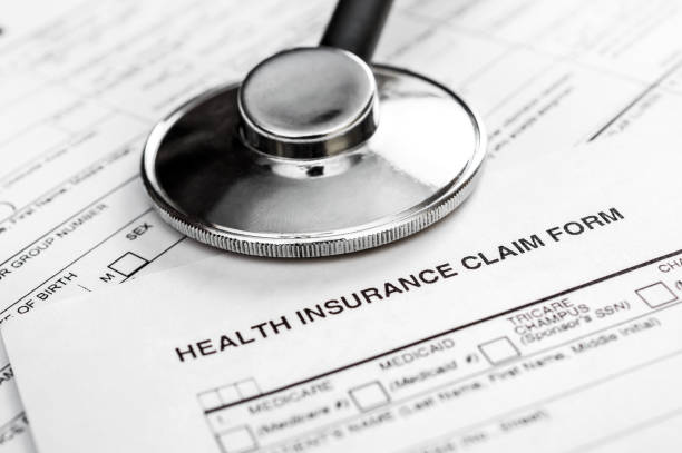 stethoscope on health insurance claim form. close up. - health insurance imagens e fotografias de stock