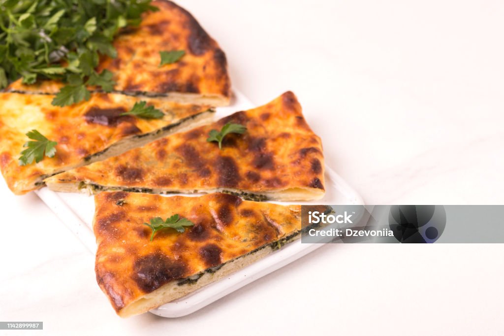 Khachapuri Megrelian with spinach and parsley. Pita bread with cheese Traditional georgian cuisine. Khachapuri Megrelian with spinach and parsley. Pita bread with cheese Backgrounds Stock Photo