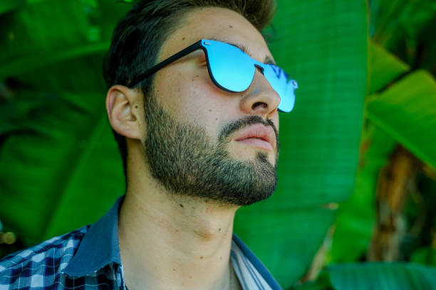 istock Cool young man by jungle leaves 1142900032