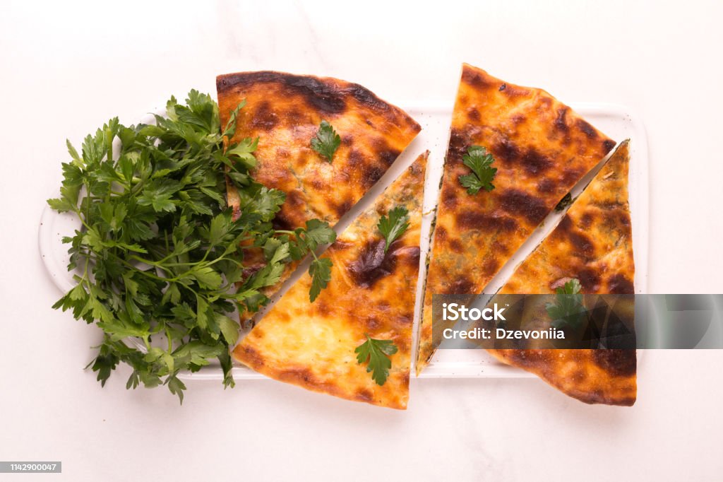 Khachapuri Megrelian with spinach and parsley. Pita bread with cheese Traditional georgian cuisine. Khachapuri Megrelian with spinach and parsley. Pita bread with cheese Backgrounds Stock Photo