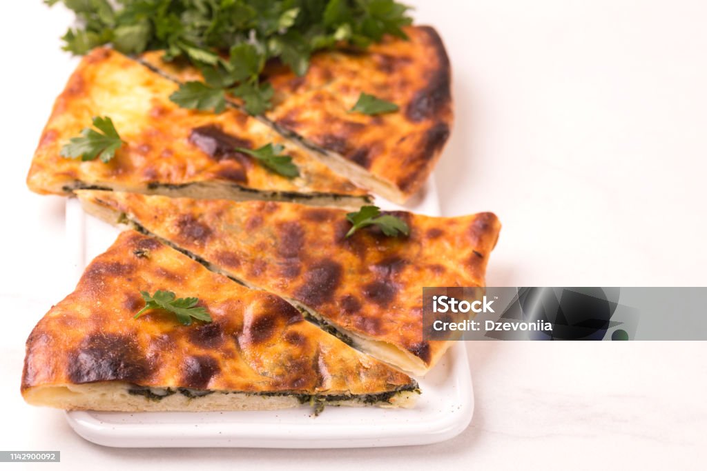 Khachapuri Megrelian with spinach and parsley. Pita bread with cheese Traditional georgian cuisine. Khachapuri Megrelian with spinach and parsley. Pita bread with cheese Backgrounds Stock Photo