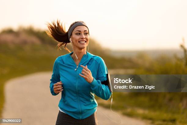 Happy Female Runner Jogging In The Morning In Nature Stock Photo - Download Image Now