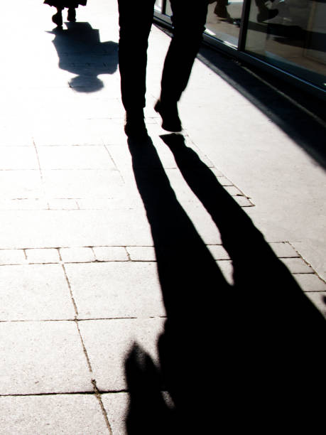 istock Blurry shadow silhouette of people walking, in black and white 1142900438
