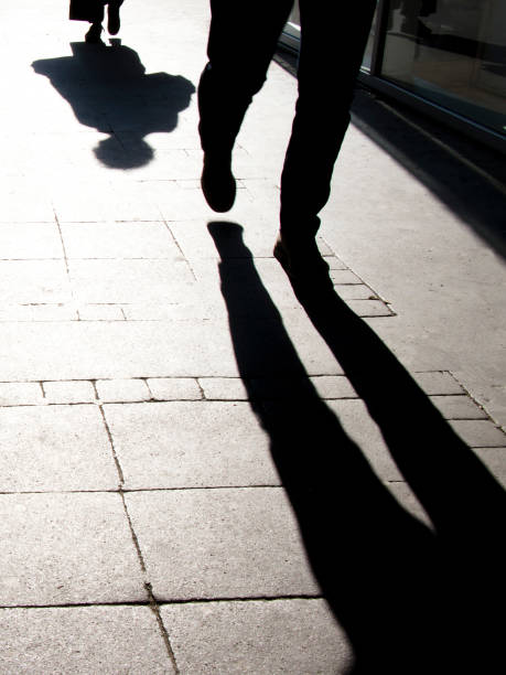 istock Blurry shadow silhouette of people walking, in black and white 1142900488