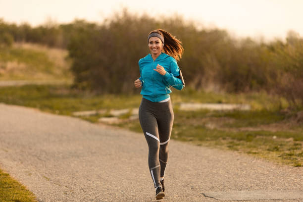 istock Happy female runner jogging on the road. 1142901818