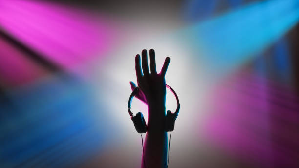 istock DJ raised his hand. Headphones in his hand 1142907549