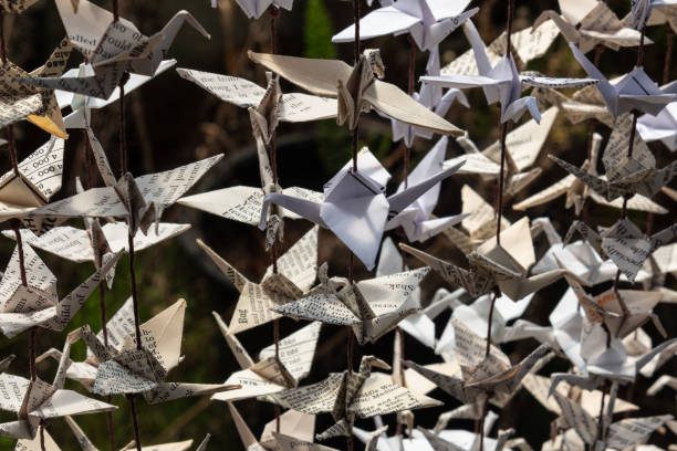 Sunlight and shadows on strings of origami paper cranes, selective focus