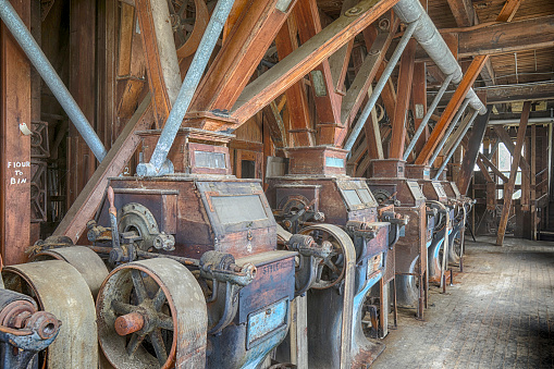Original wooden belt driven grist mill equipment inside turn of the century factory.