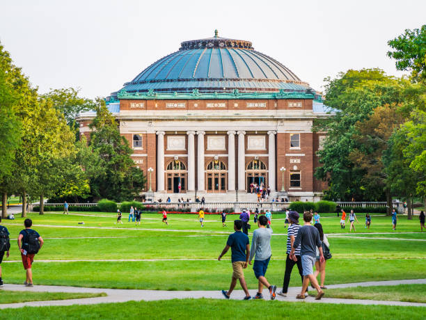 Students walk on university campus quad Urbana, Illinois, April 17, 2016 - Students walk and socialize on the Quad lawn of the University of Illinois college campus in Urbana Champaign midwestern state university stock pictures, royalty-free photos & images