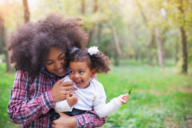 madre afroamericana y su hija. - baby mother summer park fotografías e imágenes de stock