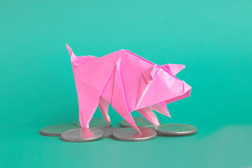 Origami art. Child folding paper on light blue background, closeup and top view
