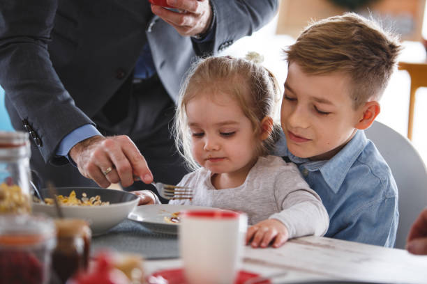 istock Father giving breakfast to his children 1142928546