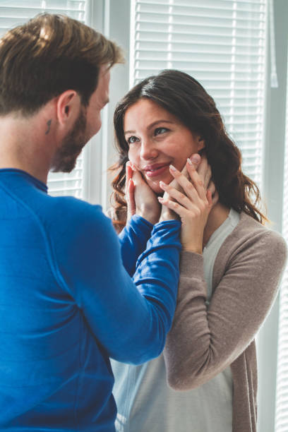 istock Man in love holding woman's face 1142929506