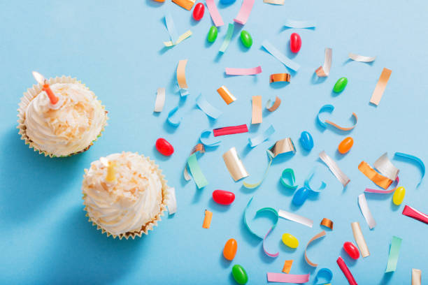 istock birthday hat with confetti and cupcake on blue paper background 1142929619