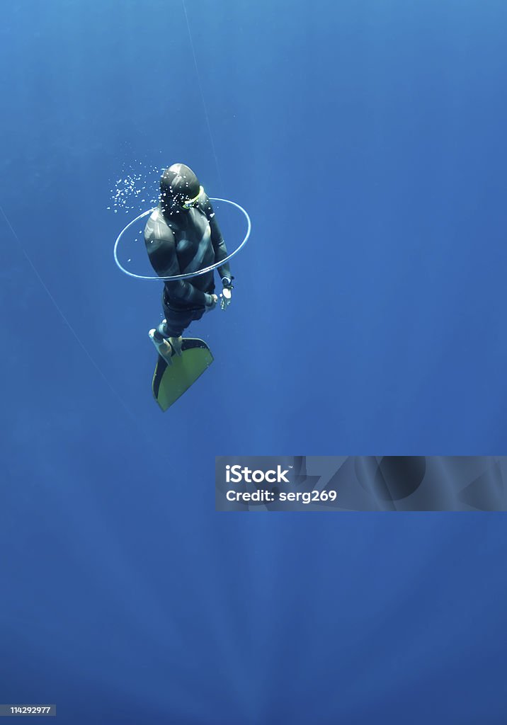 Freediver tries to swim through the bubble air ring  Adventure Stock Photo