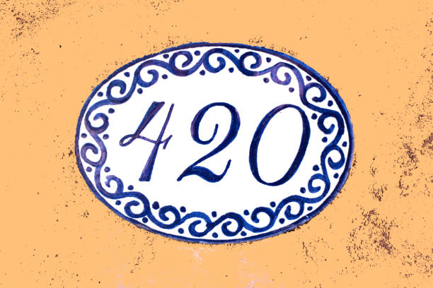 Ceramic Number 420 Street Address Tile; Orange Wall Ceramic Number 420 Street Address; Mexican blue and white tile on orange wall. Copy space available. ceramic tile house numbers stock pictures, royalty-free photos & images