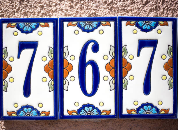 Colorful Ceramic Number 767 Street Address Tile Ceramic Number 767 Street Address; Colorful Mexican floral tiles on adobe wall. ceramic tile house numbers stock pictures, royalty-free photos & images