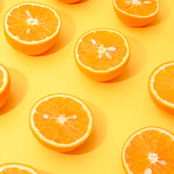 istock Orange juicy oranges split in half on yellow 1142953400