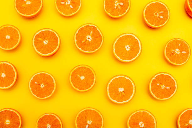 istock Orange juicy oranges split in half on yellow 1142953659