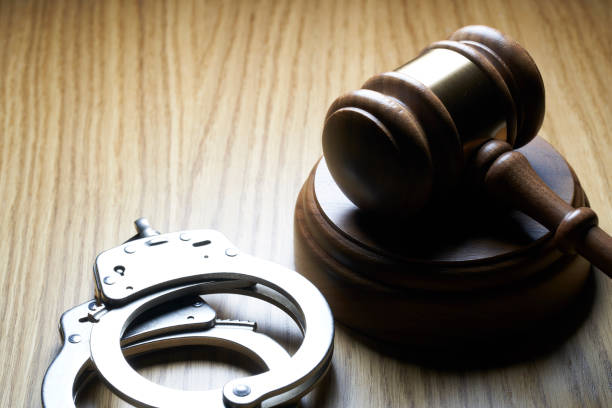istock Gavel and handcuffs on wood table: 1142957048