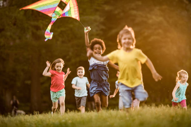 istock Happy kids playing with kite in springtime at the park. 1142965168