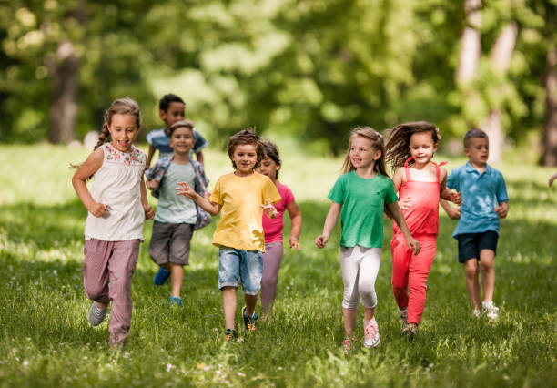 istock Large group of happy kids having fun while running in springtime. 1142965736