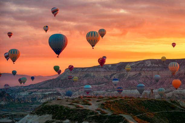 Hot Air balloons flying tour over Mountains landscape spring sunrice Cappadocia, Goreme Open Air Museum National Park, Turkey nature background. stock photo