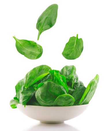 front view of fresh spinach in a white bowl
