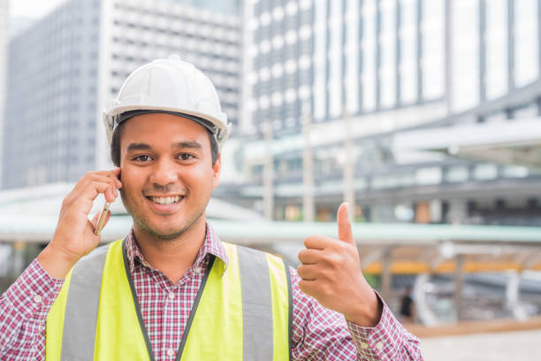 istock Young handsome asian civil engineer smiling and talking on phone while showing thumb up. 1142970434