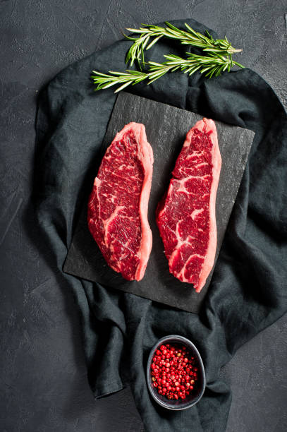istock sirloin a raw beef steak. Black background, top view. 1142971887