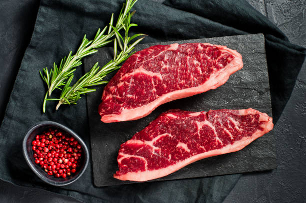 istock Steak of marbled beef black Angus. Black background, top view. 1142971992