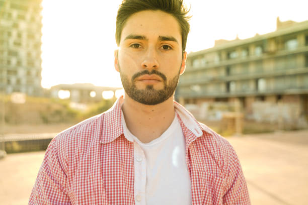 Stylish young man under city sun. Visible lens flares.