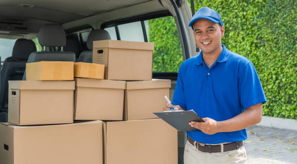 Blue Delivery man holding parcel cardboard box. stock photo