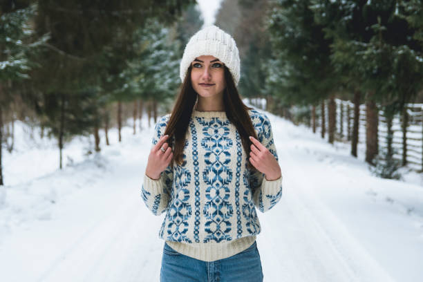 istock Young woman hikes down snowy road 1142980417