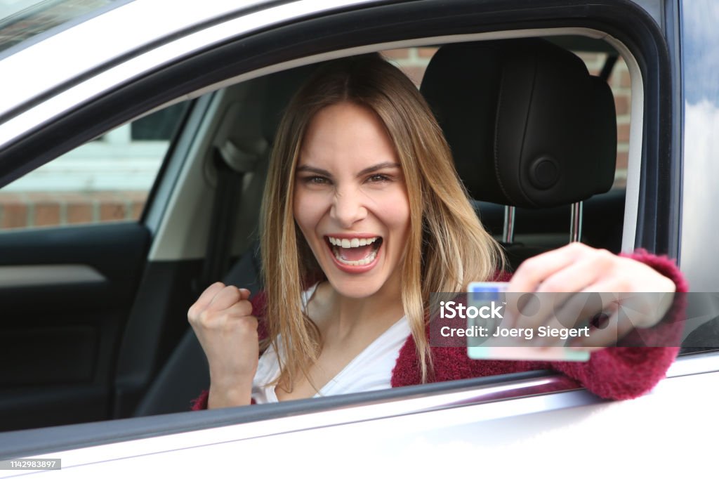 Glückliche Frau freut sich über die bestandene Fahrprüfung und zeigt ihren Führerschein - Lizenzfrei Führerschein Stock-Foto