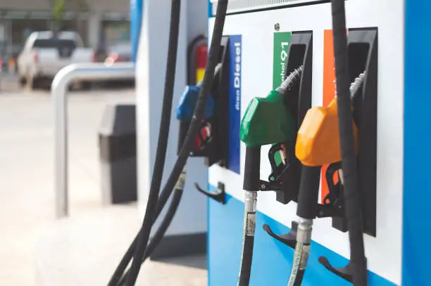 closeup of colourful fuel pumps at a gas station with sofe-focus and over light in the background