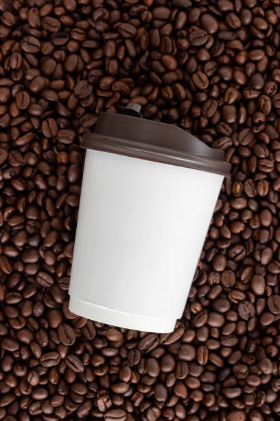 istock white paper cup on coffee bean background. top view 1142984243