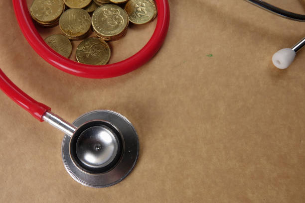 istock High Angle View Of Stethoscope With Coins On Brown Table 1142988245
