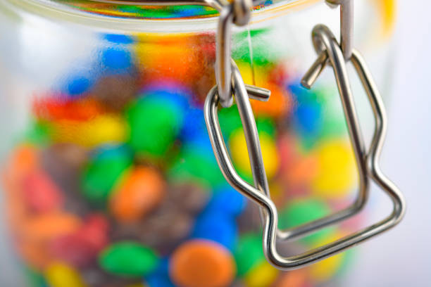 Green, blue, red, orange, brown chocolate candies in store, full frame.