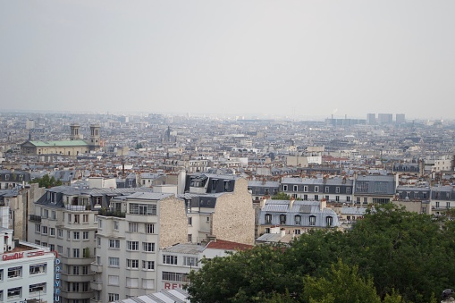 Hazy Paris skyline from Montmartre, France. No famous landmarks, simply busy crowded low level housing, with taller modern buildings in misty distance