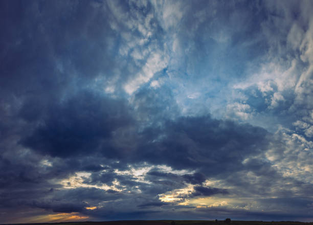 blue cloudy sky over the city with golden sun ray at dusk