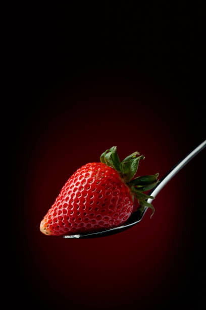 istock Strawberry in spoon on a dark background. 1143000302