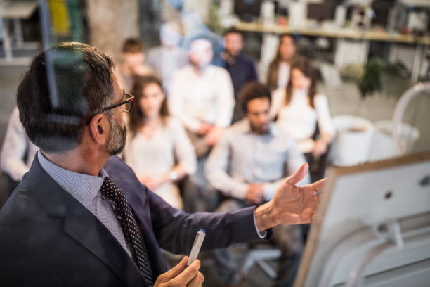 istock Mature businessman giving a presentation to his colleagues on a training class. 1143000622