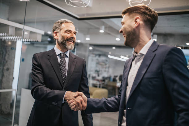 istock Two happy businessmen shaking hands in the office. 1143001697