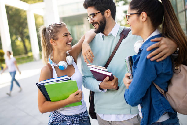 istock Happy university friends studying together in college 1143005220
