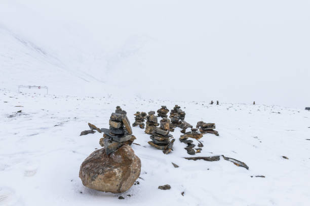 pietre mani sul innevato passo di montagna nagenla (o la ghan la) sul nord della catena montuosa dei monti nyenchen tanglha, contea di damxung (dangxiaong), lhasa, tibet, cina. - ghan pass foto e immagini stock