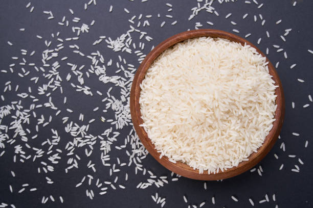 istock rice grains in a wooden bowl on black table 1143007548
