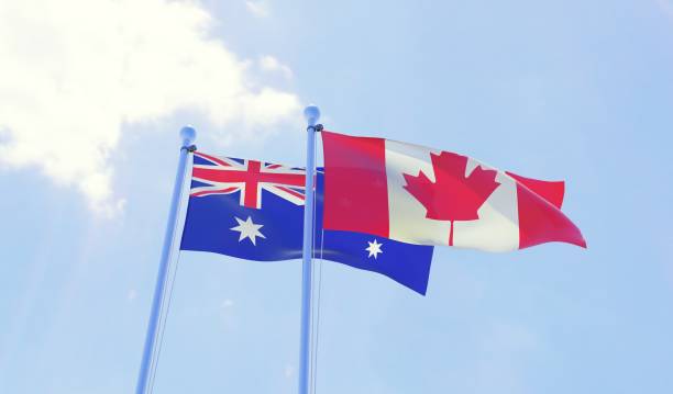 istock Australia and Canada, two flags waving against blue sky 1143010157